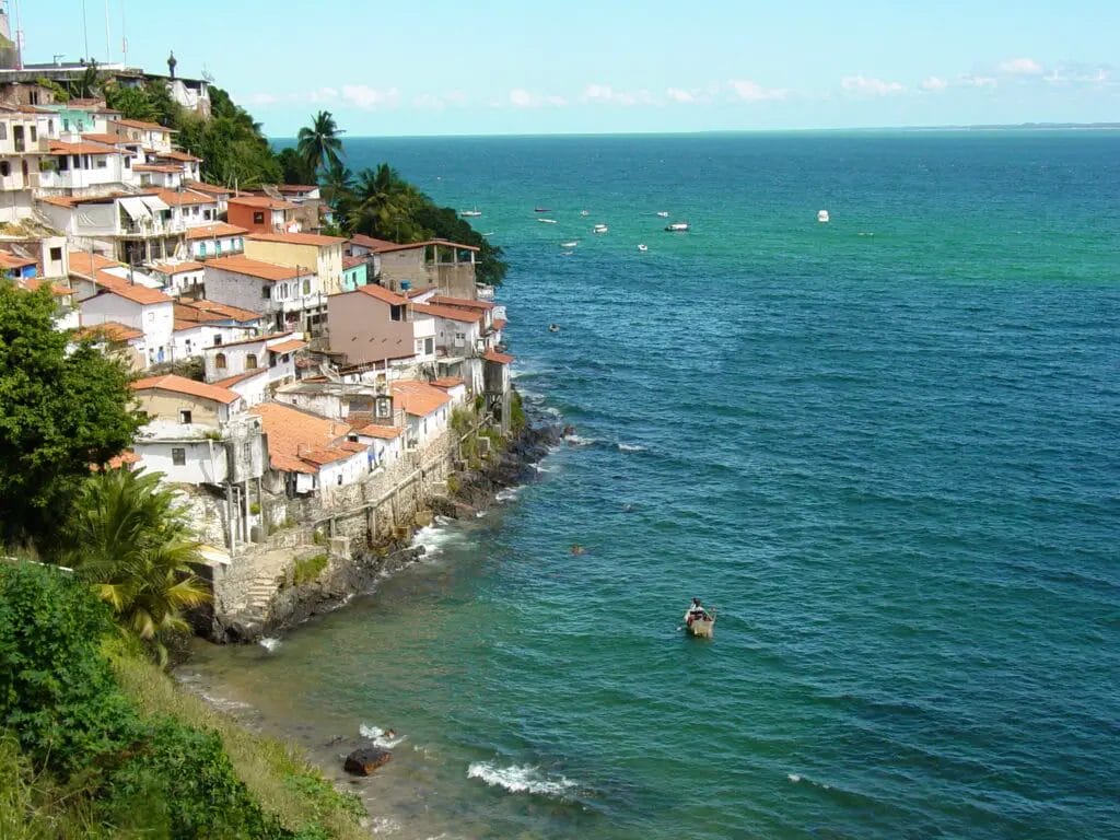 a group of buildings on a cliff next to a body of water