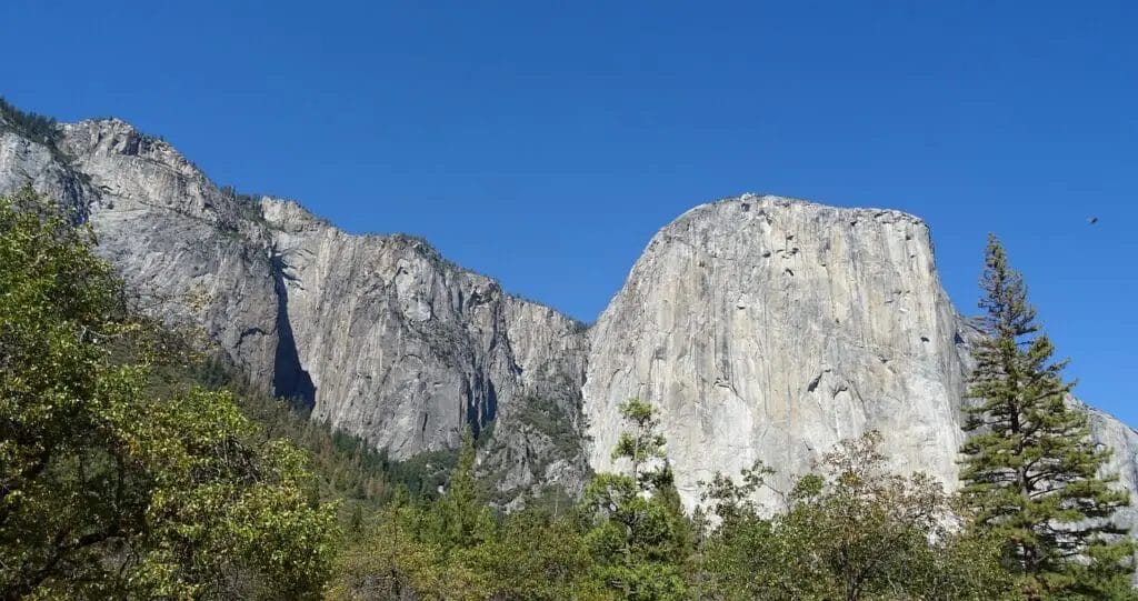 a large rock formations with trees in the background