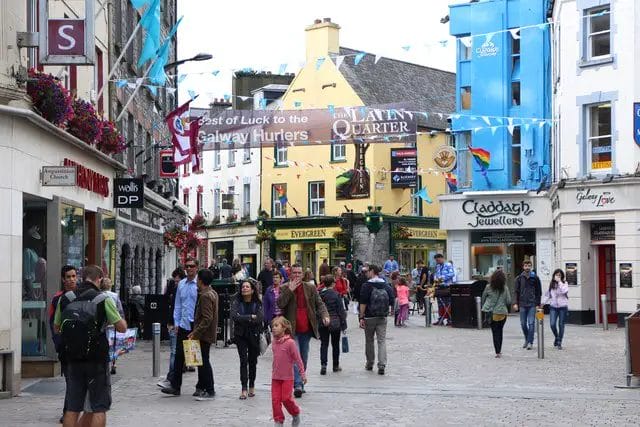 a group of people walking in a city in Galway, Co. Galway